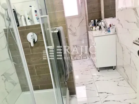 Modernly equipped bathroom with a shower cabin and sink. - image 11