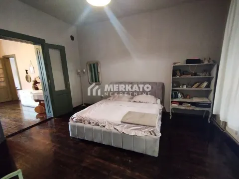 Prostrana spavaća soba sa bračnim krevetom, policom za knjige i pogledom na susednu prostoriju. - image 15