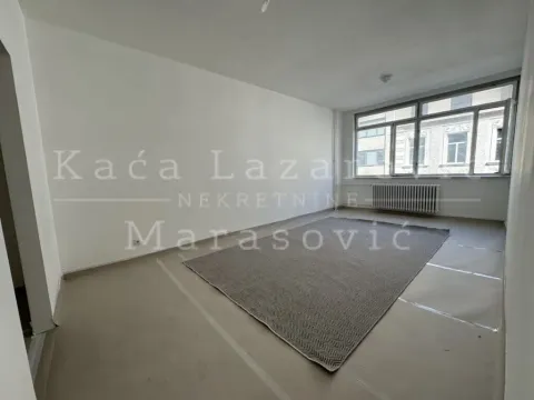 Empty room with a large window and a rug on the floor. - image 15