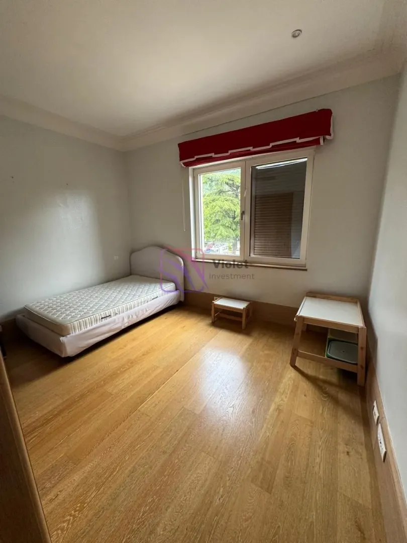 Small bedroom with a bed and wooden floor.