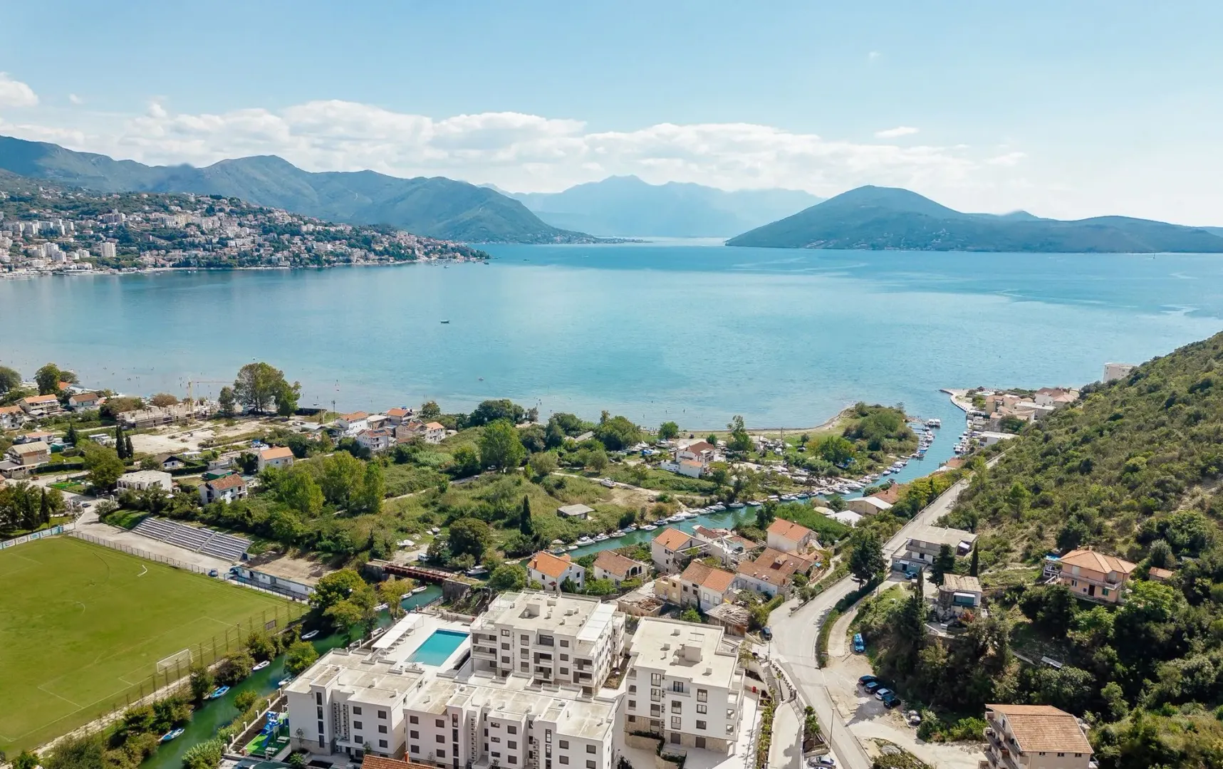 Pogled iz vazduha na zaliv, okolna naselja i planine u pozadini.