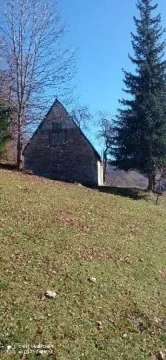 Pogled na staru kamenu kuću okruženu prirodom. - image 4