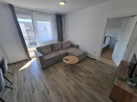 Dnevna soba sa ugaonom garniturom, stočićem i izlazom na balkon. - image 2