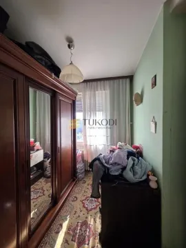 Manja spavaća soba sa velikim drvenim ormanom i tepihom. - image 10