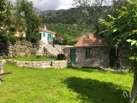 Exterior of a traditional stone house with a landscaped yard and greenery. - image 5