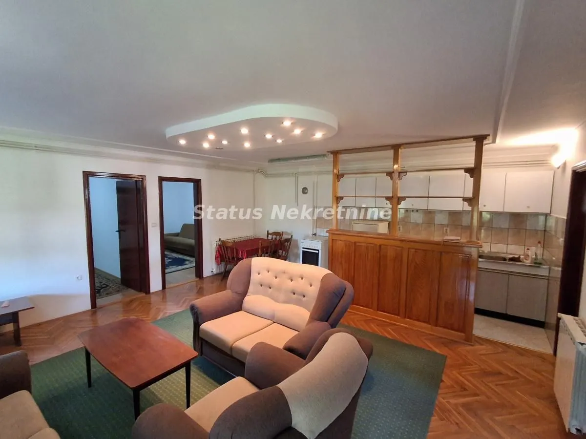 Living room with a sofa set and a dining area in the back.