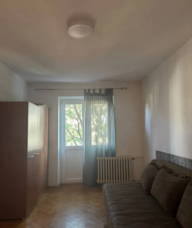 Manja spavaća soba sa krevetom, garderoberom i izlazom na terasu.