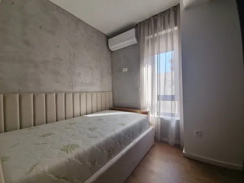 Bedroom with a bed, upholstered headboard, air conditioning unit, and a window with curtains. - image 7