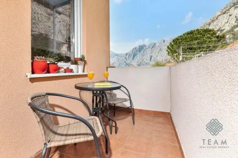 Small furnished balcony with a table, chairs, and mountain view. - image 15