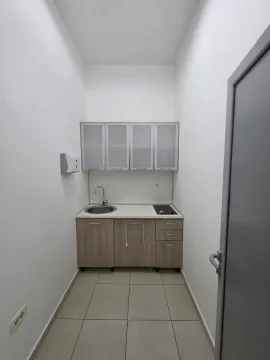 Small kitchenette in white and wood tones with a sink and countertop. - image 4