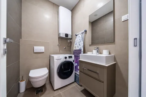 Modern bathroom with washing machine, washbasin and toilet. - image 13