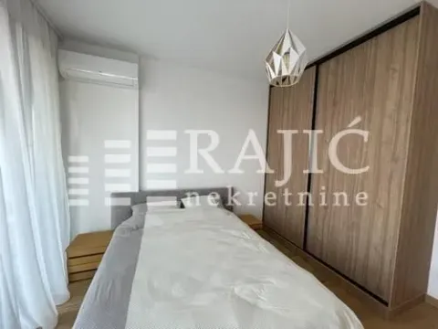 Modern bedroom with a double bed, large wooden wardrobe, and air conditioning. - image 6