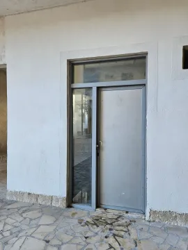 Entrance door of a commercial space or building with a white facade. - image 10