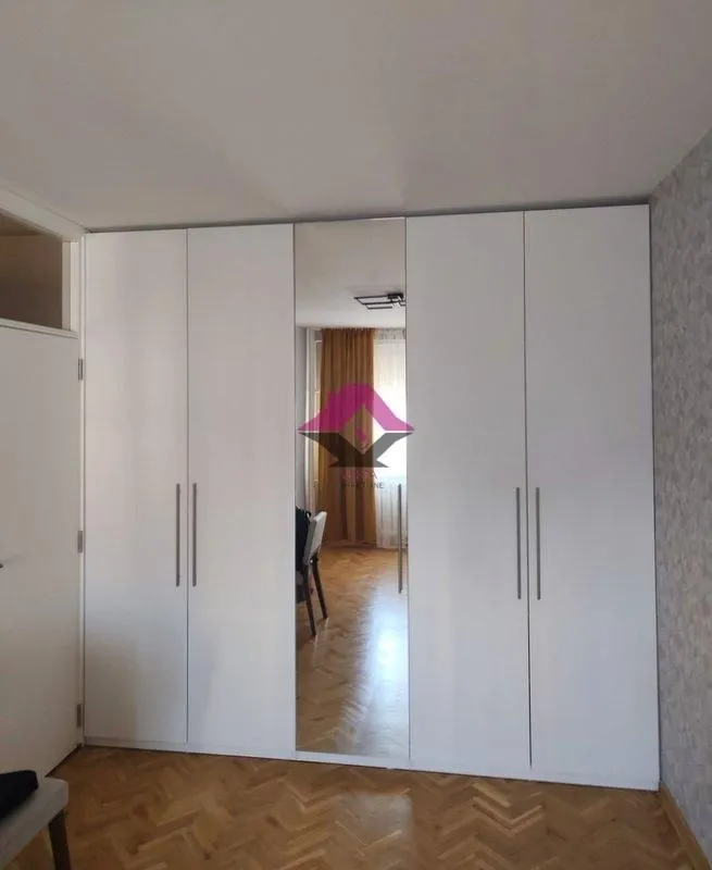 White wardrobe with a mirror in the bedroom.