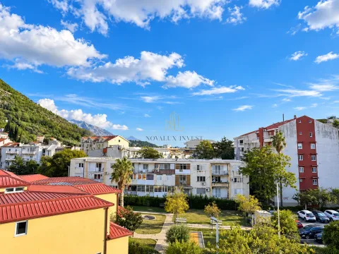 Pogled iz stana na okolne zgrade, zelene površine i planine u pozadini. - image 12