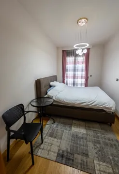 Small bedroom with a double bed, a rug, and a modern chandelier. - image 12
