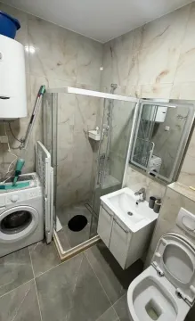 Manje opremljeno kupatilo sa tuš kabinom, umivaonikom i veš mašinom. - image 8