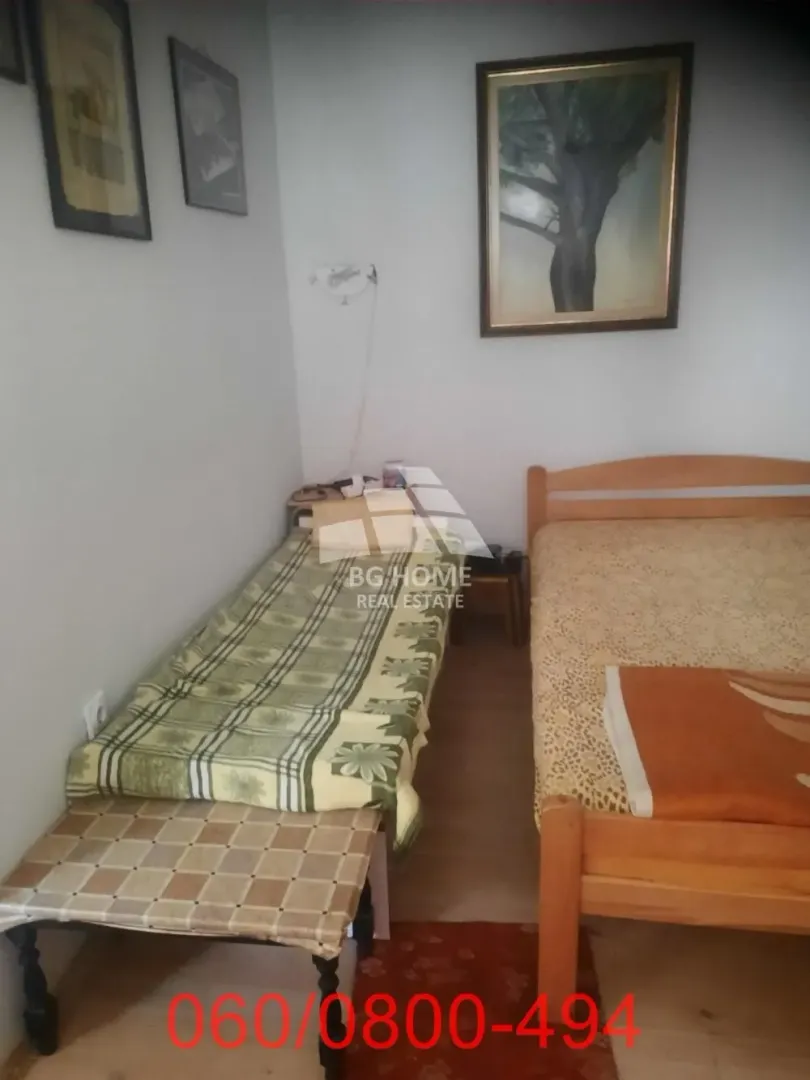Bedroom with two wooden beds and wall paintings.