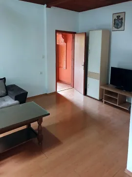 Living room with a sofa, television, and wooden flooring. - image 8