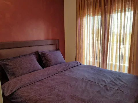 Bedroom with a double bed and a window with curtains. - image 11