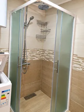 Modern bathroom with a shower cabin and ceramic tiles. - image 6