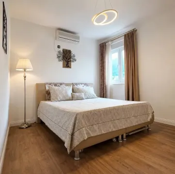 Furnished bedroom with a double bed and wooden flooring. - image 9