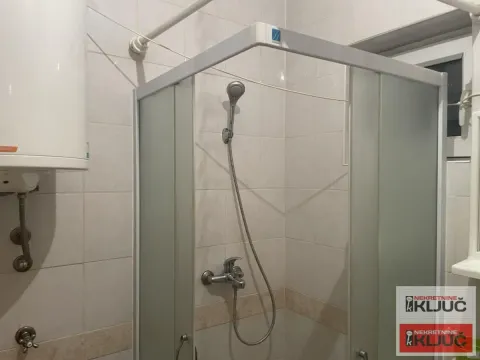 View of the shower cabin and water heater in the bathroom. - image 7