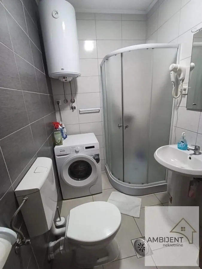 Kompaktno kupatilo sa tuš kabinom, umivaonikom, wc šoljom i veš mašinom.
