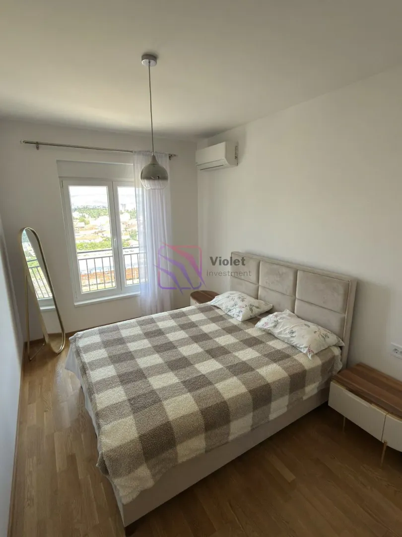 Furnished bedroom with a double bed, window, and view.