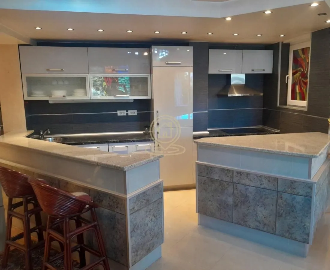 Modern kitchen with a breakfast bar and fitted appliances.