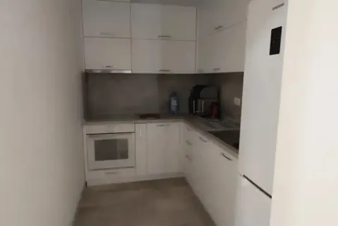 Small kitchen with white cabinets and appliances. - image 12