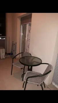 Balcony with a table and two chairs. - image 12