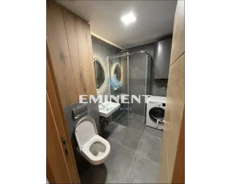 Modern bathroom with a walk-in shower, washbasin, toilet, and washing machine. - image 3