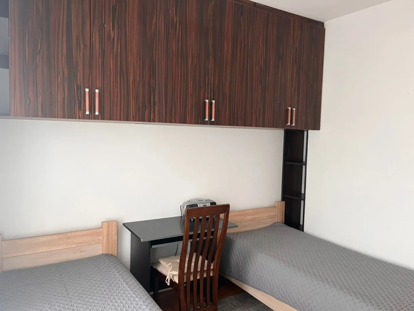 Bedroom with two beds and a desk.