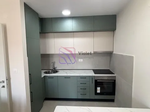 Modern kitchen with green and white cabinets and built-in appliances. - image 2