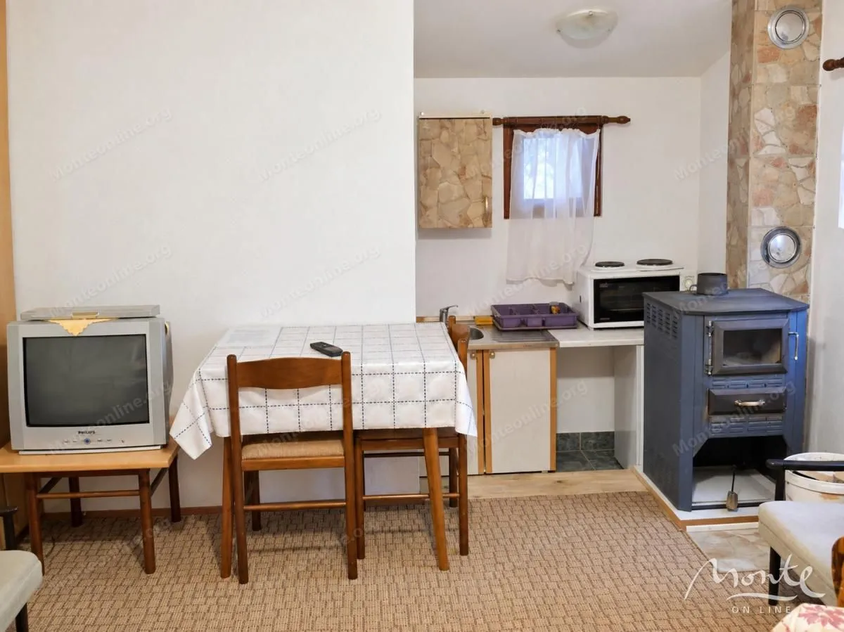 Smaller kitchen with a dining table and wood stove.