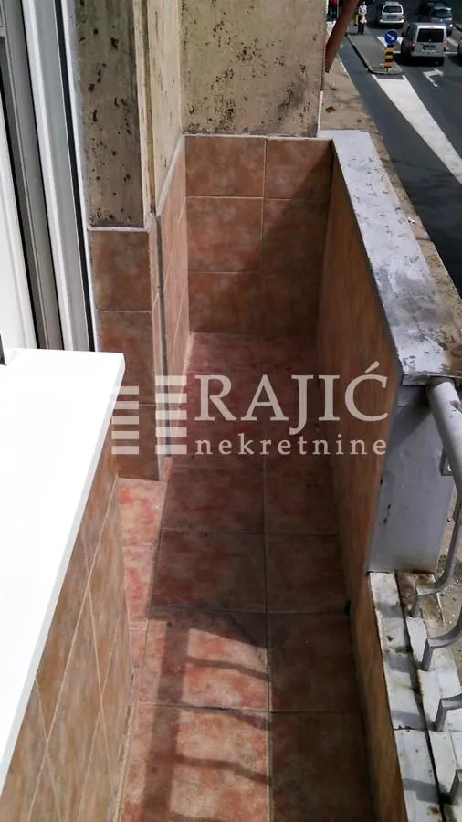 Smaller tiled balcony with a street view.