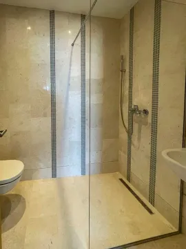 Kupatilo sa tuš kabinom i keramičkim pločicama u bež tonovima. - image 7