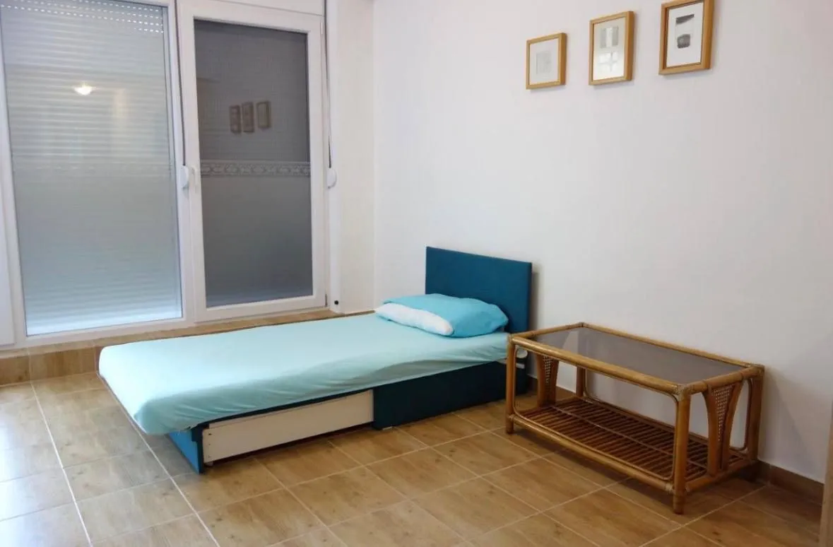 Namještena spavaća soba sa krevetom i malim stočićem.