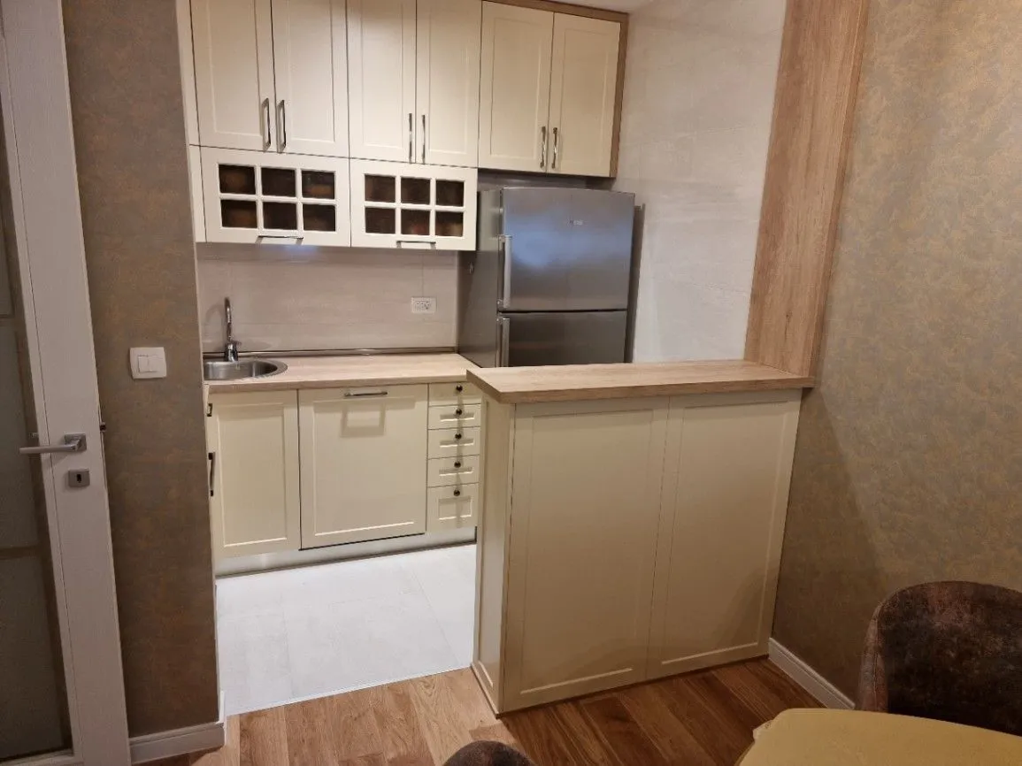 Modern kitchen with light-colored cabinets and a refrigerator.