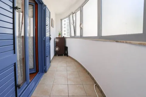 Enclosed balcony with tiled flooring and blue shutters. - image 9
