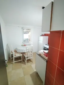 Smaller kitchen with a dining table and white cabinets. - image 10