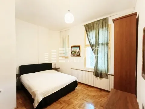 Furnished bedroom with a double bed, window, and wooden wardrobe. - image 8