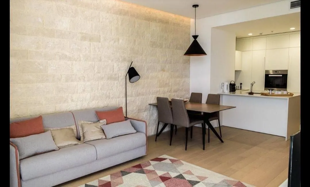 Living room with sofa, dining area, and open kitchen.