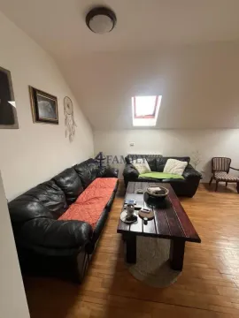 Potkrovni dnevni boravak sa kožnim garniturama i drvenim stočićem. - image 2