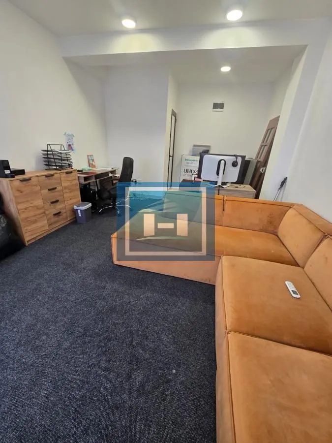 Spacious living room with a corner sofa and a desk.