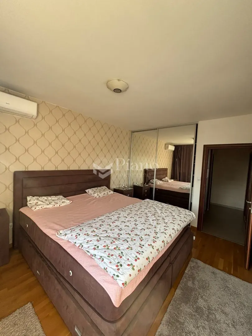 Furnished bedroom with a double bed, mirrored wardrobe, and air conditioning.