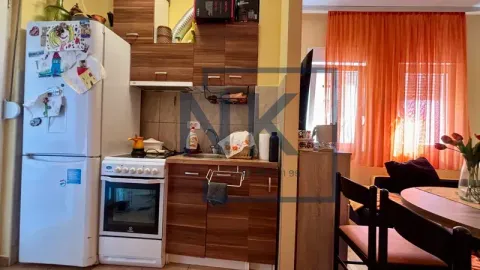 Small kitchen with wooden cabinets and white home appliances. - image 4