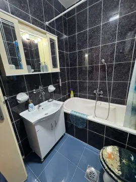 Kupatilo opremljeno umivaonikom, kadom i ormarićem sa ogledalom. - image 4