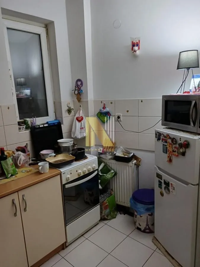 Manja kuhinja sa štednjakom, frižiderom i elementima.